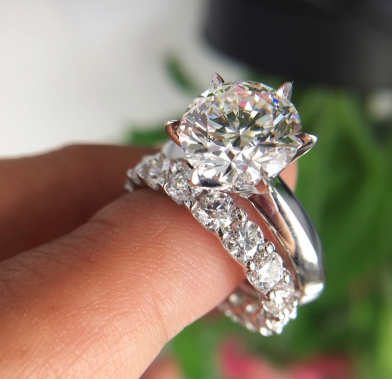 The engagement ring is a round cut diamond of more than three carats with an eternity wedding band