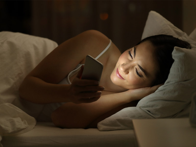girl in bed on phone