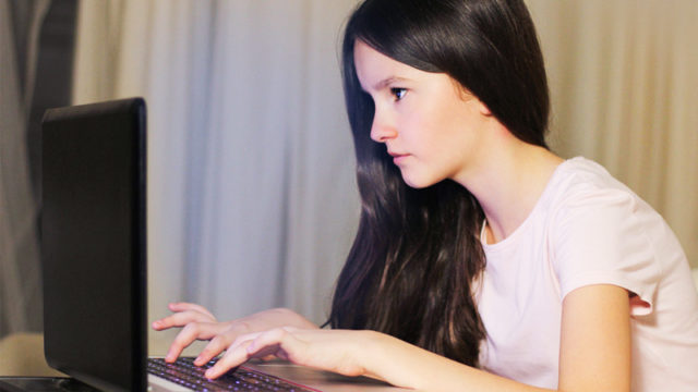 Girl on laptop for article on internet pornography among children