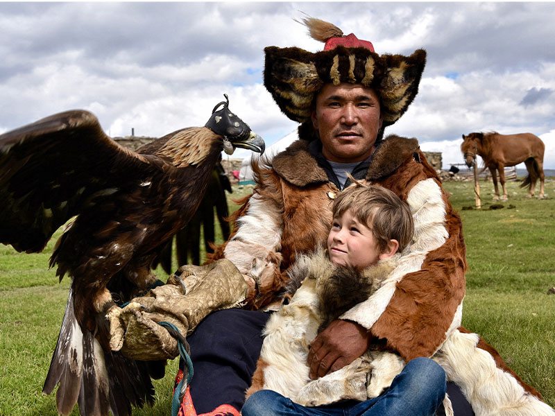 Mongolia adventure holiday - boy with nomad holding eagle