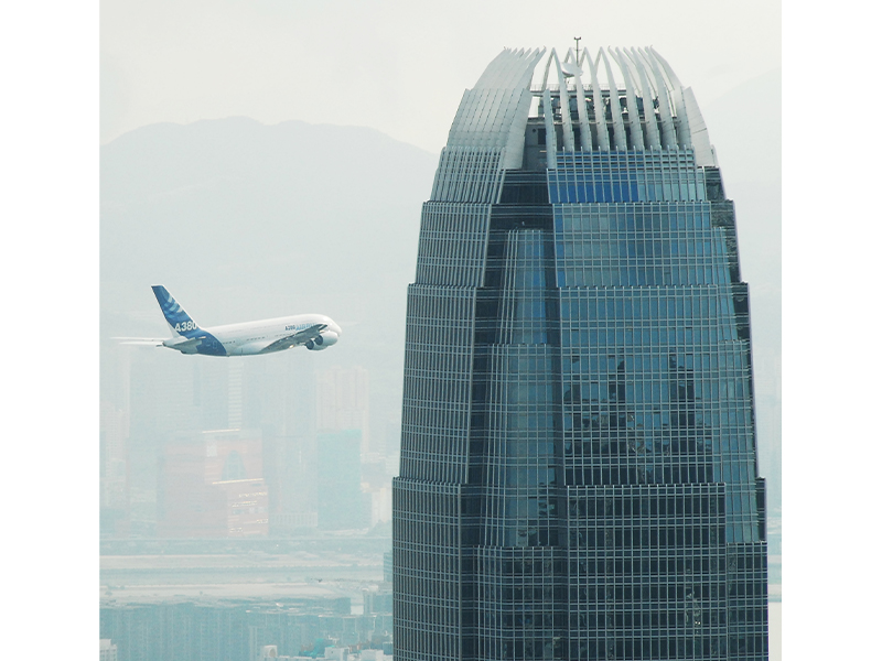 Plane by building in Hong Kong by photographer Laurence Lai