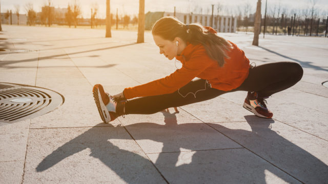 Woman stretching for article on running and heart health