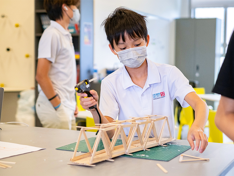 Self-directed learning at Hong Kong Academy - student constructing a wooden bridge